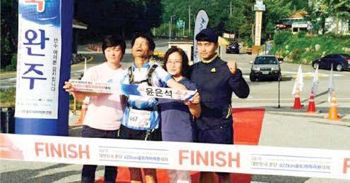 지난 11일 `대한민국 종단 622km 울트라마라톤대회`에서 완주에 성공한 윤은석<왼쪽서 2번째> 씨가 가족들과 결승선 앞에 섰다.   사진=대한울트라마라톤 연맹 제공