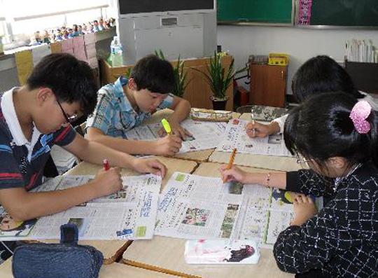 부여 백제초 학생들이 사회의 ‘핫이슈’를 다룬 신문의 사설 내용을 요약하고 있다. 사진=부여 백제초 제공