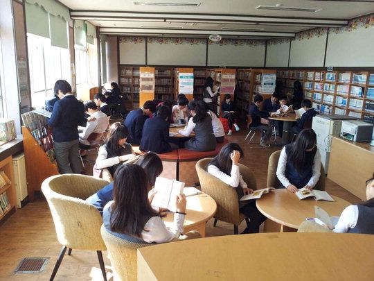  천북중 학생들이 학교 도서실에서 삼삼오오 모여 독서하고 있는 모습.