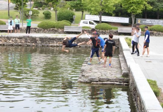 성년의 날 충남대 영탑지 연못에 학생들이 성년이 된 남학생을 빠뜨리고 있다.
