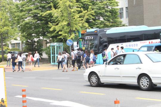 사진=충남대 순환버스 정거장에 학생들과 여러 차들이 어지럽게 서 있다. 
