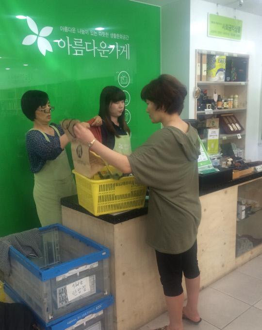 아름다운 가게 매니저들이 손님의 물품을 계산하고 있다. 
