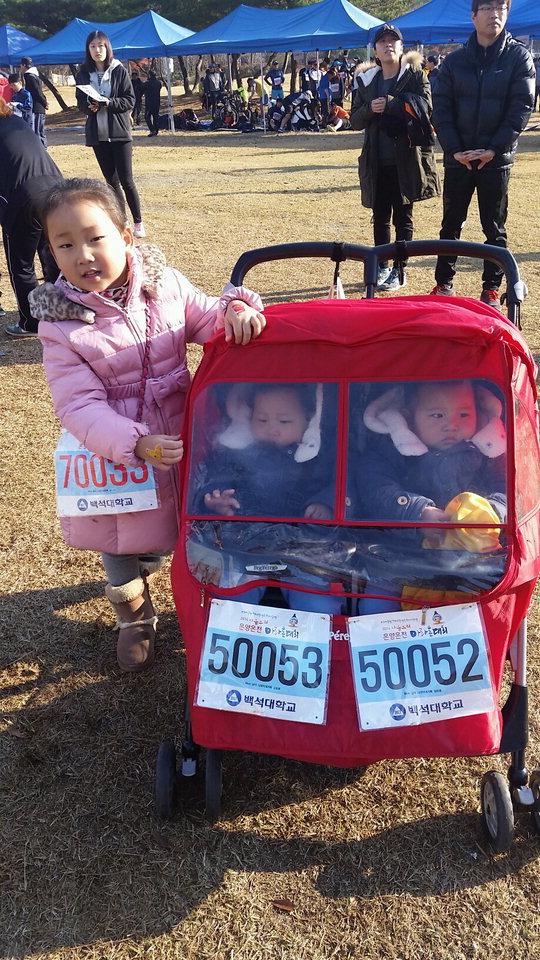 2인승 유모차에 탄 16개월된 쌍둥이가 가족과 함께 대회에 참가해 기념촬영을 하고 있다.  임시취재반
