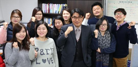 손용진(앞줄 가운데) 우리미디어 대표가 임직원들과 함께 파이팅을 외치고 있다.  윤평호 기자
