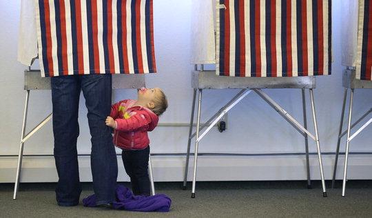 미국 연방 상원의원 36명과 하원의원 435명을 선출하는 중간선거가 치러진 작년 11월 4일 알래스카주 앵커리지의 한 투표소에서 한 어린이가 투표하고 있는 부모를 쳐다보고 있다.  [AP=연합뉴스]
