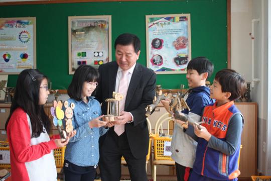 이건표(가운데) 대전삼성초 교장이 지난 해부터 직접 나무를 구해와 37가지 모양으로 자른 자연물 놀이세트를 학생들에게 만들어주고 있다.  김예지 기자