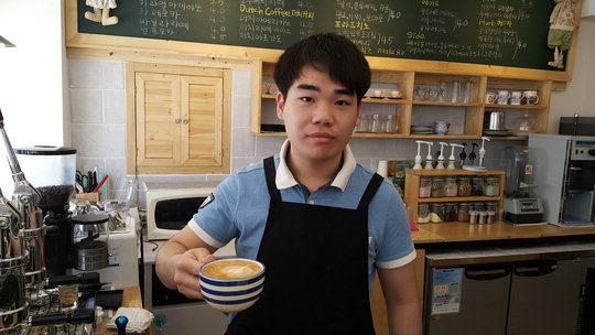  카페라떼를 가장 잘 만들 수 있다는 임은택 카페 '메누하' 사장이 커피를 들어보이고 있다. 이호진 기자

