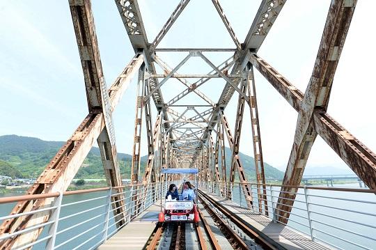 관광객들이 레일바이크를 타고 낙동강 철교를 건너고 있다.
