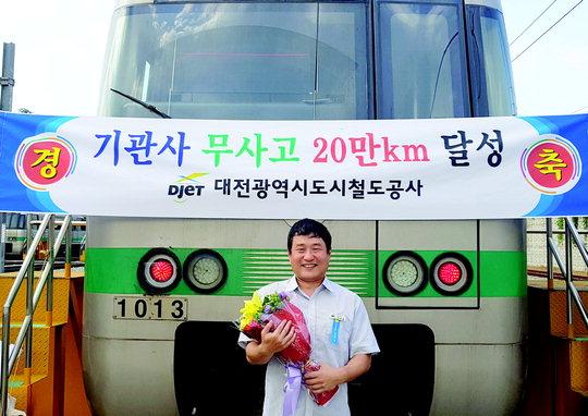 지난 23일 대전도시철공사 승무팀 이상호 기관사가 46번째로 무사고 20만km를 달성한 뒤 축하 꽃다발과 함께 기념촬영을 하고 있다.  사진 = 대전도시철도공사 제공