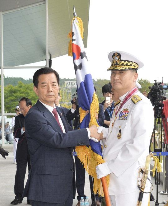 엄현성(오른쪽) 제 32대 해군참모총장이 한민구 국방부장관으로부터 해군기를 받고 있다.  사진=해군본부 제공