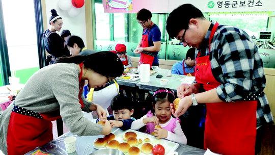  영동군 보건소가 지난 22일 보건소 영양실습실에서 운영한 '아빠와 함께하는 주말요리 교실'에 참여한 한 가족이 '동물 모닝빵 샌드위치'를 만들고 있다.   사진=영동군 보건소 제공