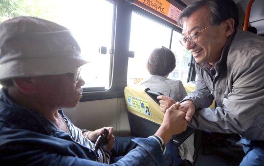  지난 22일 청주를 찾은 새누리당 이정현(오른쪽) 대표가 시내버스에서 시민과 인사를 나누고 있다.  [연합뉴스]