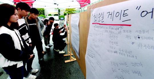 최순실씨 `국정농단` 의혹과 관련 대전지역 대학가의 시국선언이 이어지고 있는 가운데 28일 충남대학교 학생들이 교내에 게시된 `최순실 게이트` 대자보에 의견을 쓰고 있다.  빈운용 기자