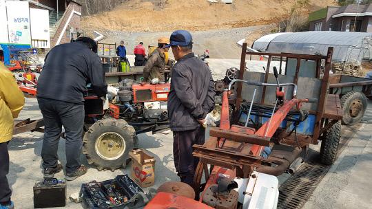 서산시 농업기술센터 직원들이 농기계를 수리하고 있는 모습

