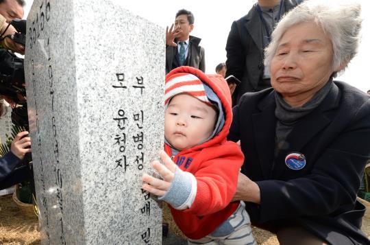 제2회 서해수호의 날인 지난 24일 대전시 유성구 국립대전현충원 천안함 46용사 묘역에서 故 민평기 상사 어머니와 둘째 형의 아들이 묘비를 어루만지고 있다. 신호철 기자