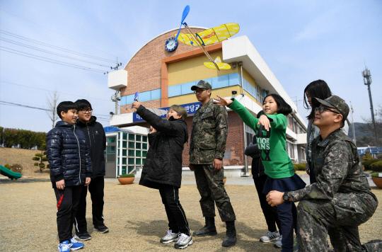 항공교실 교사로 활동하는 20전비 장병과 관당초등학교 학생들이 모형항공기 날리기 실습을 하고 있다. 사진= 김송주 원사 제공
