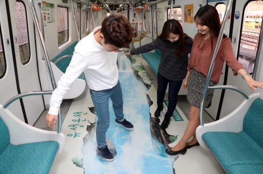 대전 유성구는 유성온천 이미지를 적용한 트릭아트를 도시철도 1호선 전동차 바닥에 래핑했다. 사진=대전 유성구 제공 
