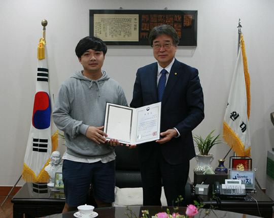 박노권 총장이 26일 `제37회 장애인의 날`을 맞아 공로자로 선정된 대학원생 김만섭 씨에게 교육부장관 표창장을 전달하고 있다. 사진=목원대 제공
