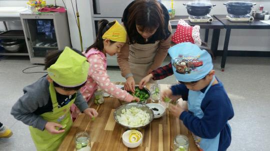 옥천군보건소가 추진하는 병아리요리교실에서 선생님과 함께 아이들이 직접 채소음식을 만들어 먹어보며 저염식 식생활 중요성을  일깨우고 있다. 사진=옥천군 보건소 제공
