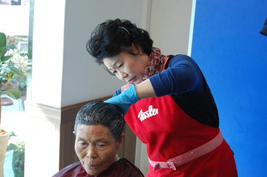 구세군 대천교회 봉사단원이 지역의 한 독거노인의 머리 염색을 도와주고 있다. 사진=구세군 대천교회 제공
