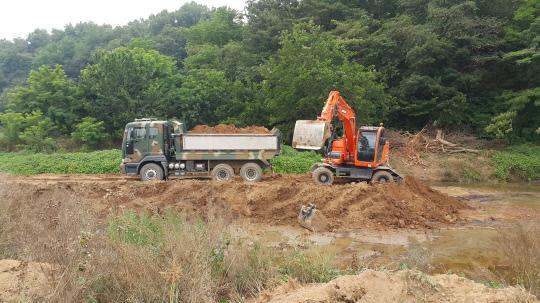 지난 28일 오전 홍성군 은하면 덕실리의 가뭄 현장에서 32사단 공병대대의 덤프 차량(왼쪽)이 흙을 담아 나르고 있다. 사진=홍성군 제공
