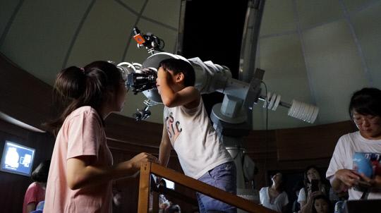 칠갑산천문대를 찾은 학생들이 국내 최대급의 굴절망원경(304mm)으로 천체 관측을 하고있다.사진=청양군 제공
