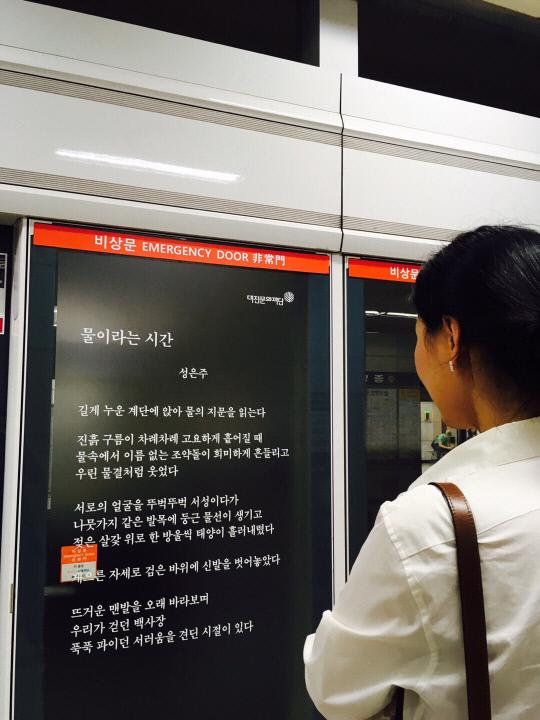 대전지하철 안전문에 부착된 시를 시민이 보고 있다. 사진=대전문학관 제공

