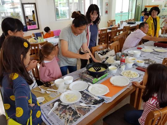 수정초등학교(교장 류동훈)학생과 학부모들이 함께 공부하고 있는 다문화가정 학부모의 설명을 받으며 베트남음식을 만들어 보고 있다.사진=청양교육청 제공
