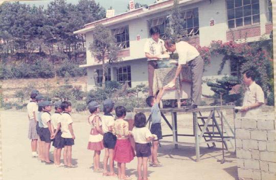 개교 100주년을 맞은 부강초등학교의 1970년대 아침조회 풍경. 철제연단 위의 교장선생이 학생들에게 상장을 주고 있다. 사진=부강초 제공
