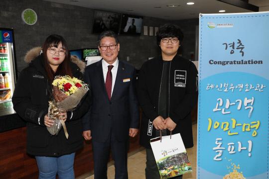 박세복 영동군수가 영동레인보우영화관 개관 10만 번째 관람객에게 꽃다발을 주고 축하하고 있다. 사진=영동군 제공.
