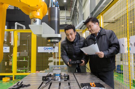 이석우 수석연구원(오른쪽)과 김태곤 선임연구원이 유연가공시스템에 들어가는 다관절 로봇을 활용해 탄소섬유복합재에 드릴링 가공을 시도하고 있다. 사진=한국생산기술연구원 제공
