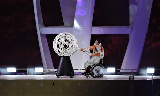 9일 평창 올림픽스타디움에서 열린 2018 평창동계패럴림픽 개회식에서 휠체어컬링 대표팀의 서준석이 컬링국가대표 `안경언니` 김은정이 밀어주는 휠체어를 타고서 최종점화를 하고 있다.
