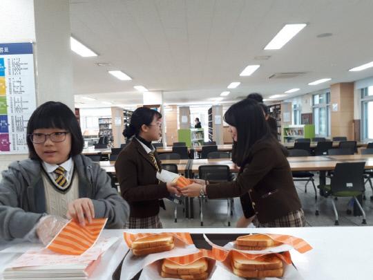 두루중학교 재학생들이 도서관을 찾아온 학생들에게 직접 구운 토스트를 나눠주고 있다. 사진=세종시교육청 제공
