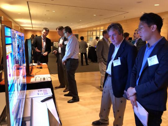 지난 23일(미국시간) 미국 워싱턴 DC에서 열린 국제 표준화기구 ATSC 정기총회에서 일반 참관자들이 `다채널 HD 스케일러블 기술` 라이브 방송을 보고 있는 모습. 사진=ETRI 제공
