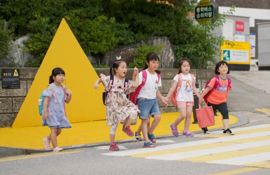 지난 10일 아산 천도초등학교 학생들이 옐로카펫이 설치된 횡단보도에서 하교하고 있다. 사진=삼성디스플레이 제공

