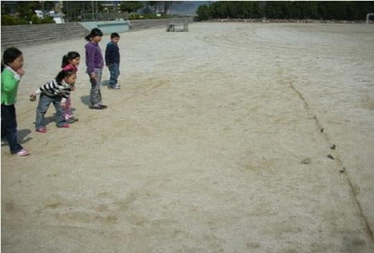 어린이들이 운동장에 금을 그어놓고 비석치기 놀이를 하는 모습. 사진=연기향토박물관 제공
