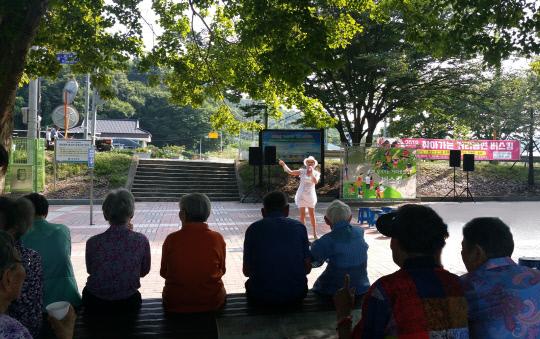 음성군은 지난 19일 생극면 응천공원에서 `찾아가는 거리공연 버스킹`을 개최했다. 사진은 주민들이 나무그늘 아래서 신나는 공연을 즐기고 있다.        사진=음성군 제공

