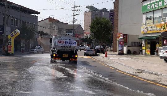 옥천군은 폭염에 따른 시가지주요도로에 도로에 물을 뿌리며 대기온도를 나추는데 노력하고 있다 . 사진=옥천군 제공
