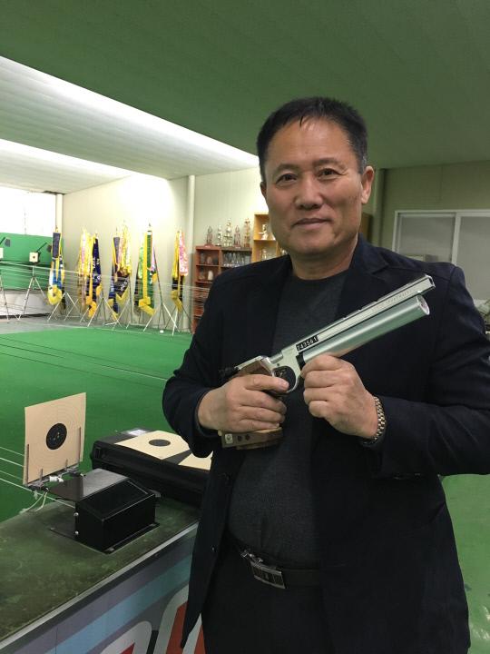 박승린 대전사격연맹 회장이 대전 대신고 사격훈련장에서 공기권총을 들고 미소짓고 있다. 사진=강은선 기자
