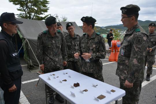국방부 유해발굴감식단이 지난 해 9월 2일 대전 세천공원에서 진행된 유해발굴 작업에서 수습한 탄피를 살펴보고 있다. 사진=육군 32사단 제공
