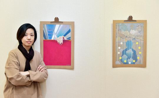 한국조폐공사는 18일부터 내년 1월 6일까지 대전 유성구 화폐박물관 특별전시실에서 지역 예술작가 신나영의 작품전 `여행, 그때 그 순간을 집다`를 개최한다. 신나영 작가가 자신의 작품 앞에서 포즈를 취하고 있다. 사진 = 한국조폐공사 제공 
