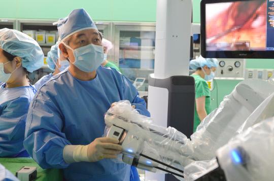 건양대병원 외과 최인석 교수가 로봇 휘플수술 집도를 위해 환자의 병변부에 로봇 팔을 도킹(결합)하는 모습. 사진=건양대병원 제공
