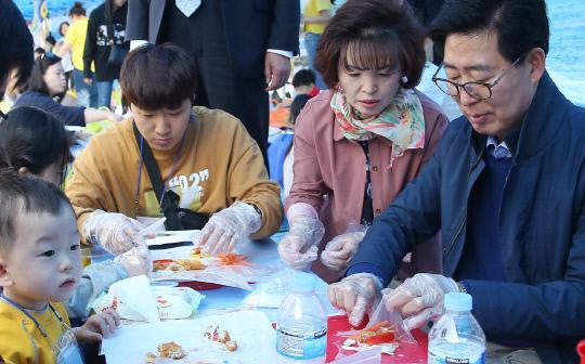 양승조(사진 오른쪽) 충남지사와 어린이들이 20일 천안 삼거리 공원에서 열린 2019 신세대 가족 수산물 체험행사에서 수산물을 이용해 음식을 만들고 있다. 사진=충남도 제공
