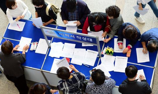 55세 이상 장년층을 대상으로 열린 `꽃장년 맞춤형 취업박람회`가 24일 대전 서구청 로비에서 열려 구직자들이 이력서를 작성하고 있다. 빈운용 기자

