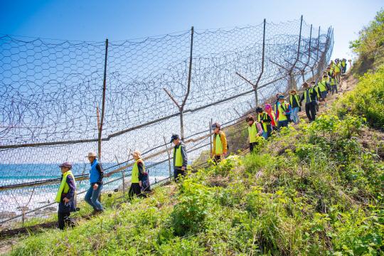 고성 DMZ 평화의길 탐방객들이 한줄로 길게 늘어서 좁은 해안철책로를 걷고 있다. [사진=고성군·강원일보]