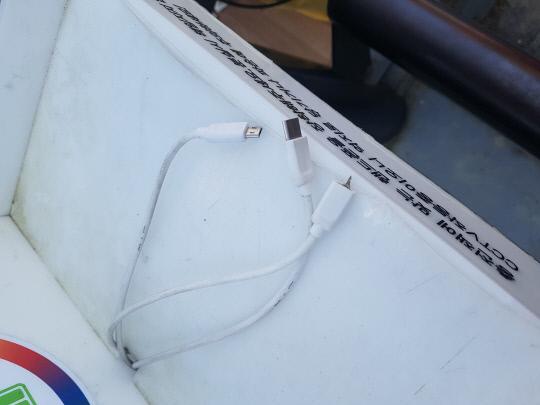 13일 복합터미널 인근 버스정류장에 설치된 충전케이블 중 아이폰충전 케이블의 잭이 손상된 모습이다. 사진=김성준 기자
