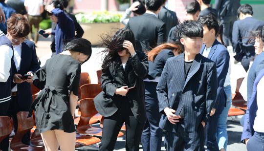 대전지역 각 대학별로 졸업앨범 사진촬영이 한창 진행중인 가운데  21일 대전시 동구 우송정보대에서 졸업앨범 촬영을 하던 학생들이 강한 바람이 불자 옷자락을 붙잡고 있다. 빈운용 기자
