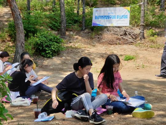 지난 24일 용봉산 자연휴양림에서 열린 자연관찰탐구대회에 참가한 학생들이  자연을 관찰한  내용을 기록하고 있다. 사진=홍성교육지원청 제공 
