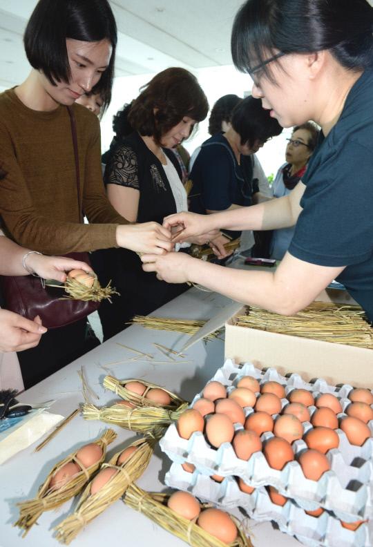 유엔이 정한 세계 환경의 날을 맞아 환경의 소중함을 되새기기 위해 5일 대전시청에서 열린 `제24회 환경의 날` 행사에서 시민들이 짚풀 계란꾸러미 만들기 체험을 하고 있다.  빈운용 기자
