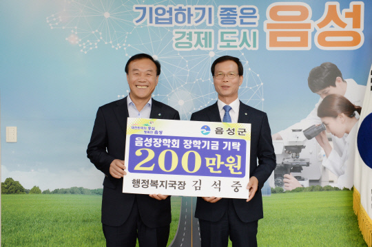 김석중 (왼쪽)행정복지국장이 명예퇴임식에서 조병옥 군수에게 장학금 200만 원을 기탁 하는 모습         사진=음성군 제공
